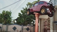 Mobil VW berpelat nomor AB 1777 XY warna merah marun ini kondisinya masih bagus. Bodi bagian bawah dipasang mur baut di tiang monumen. Tiang bertinggi sekitar tiga meter itu berada di dekat gerbang rumah dan di tepi jalan. Di bawahya dibangun tiga tempat duduk berbentuk lingkaran. Foto: Achmad Syauqi/detikcom