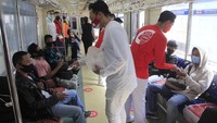 Masker dibagikan kepada para penumpang di dalam gerbong.