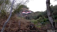 Dengan ukuran panjang 27 meter dan lebar tiga meter, pita merah putih ini dibentangkan di atas puncak tebing yang sangat tinggi agar dapat terlihat dengan jelas oleh warga dari jarak yang sangat jauh.