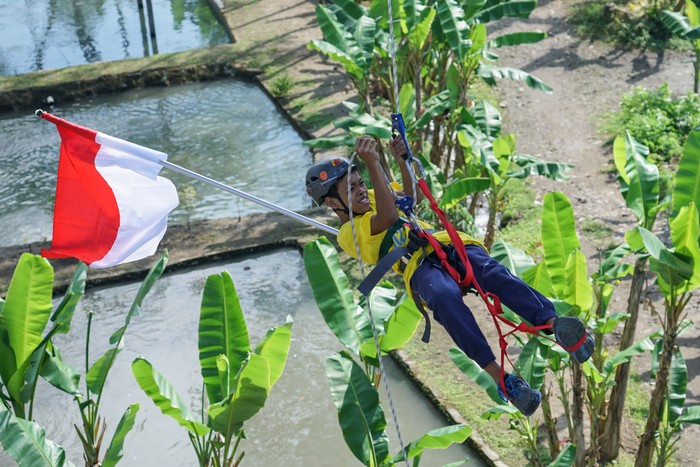 PEMBENTANGAN BENDERA OLEH PEMANJAT ANAK Sejumlah anak membentangkan Bendera Merah Putih di Jembatan Babarsari, Sleman, DI Yogyakarta, Senin (17/8/2020). Pembentangan bendera menggunakan teknik