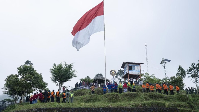 PENGIBARAN BENDERA DI LERENG MERAPI Petugas mengibarkan Bendera Merah Putih di Bukit Klangon, Cangkringan, Sleman, DI Yogyakarta, Minggu (16/8/2020). Pengibaran bendera raksasa yang diikuti anggota TNI, Polri, Warga dan Relawan tersebut untuk mengenang pertempuran di Lereng Merapi saat melawan penjajah serta menyambut perayaan HUT ke-75 Republik Indonesia. ANTARA FOTO/Hendra Nurdiyansyah/foc.