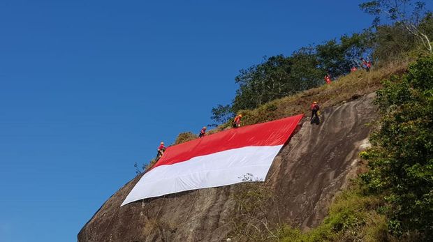 Merayakan HUT RI ke-75 sebuah bendera Merah Putih raksasa dibentangkan di tebing Gunung Bongkok, Purwakarta. Seperti apa?