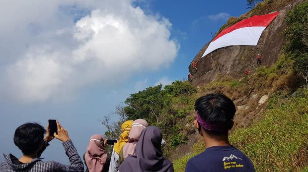 Merayakan HUT RI ke-75 sebuah bendera Merah Putih raksasa dibentangkan di tebing Gunung Bongkok, Purwakarta. Seperti apa?