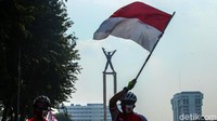 Warga mengibarkan bendera merah putih.
