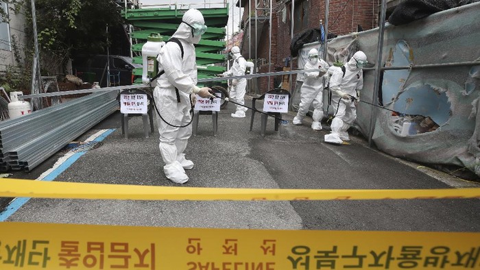 Public officials disinfect a church as a precaution against the coronavirus in Seoul, South Korea, Friday, Aug. 14, 2020. South Korea reported over 100 new virus cases Friday, one of its biggest daily jumps in months, as officials express concerned that infections are getting out of control in cities as people increasingly venture out in public. (Han Jong-chan/Yonhap via AP)