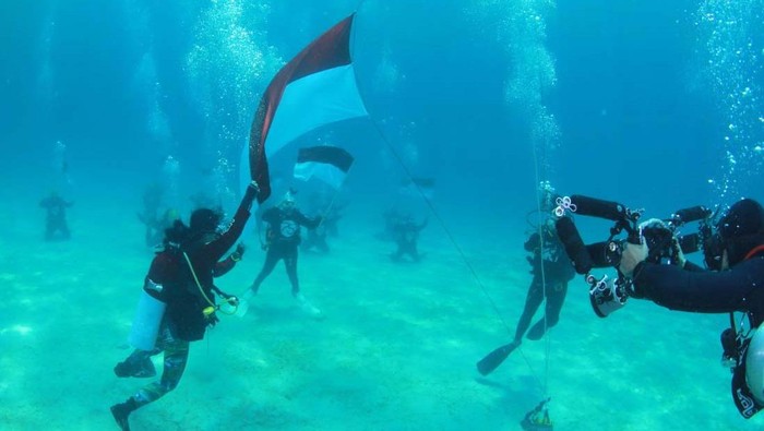 Potret Upacara Bendera di Bawah Laut Likupang Upacara peringatan HUT RI digelar di bawah laut Likupang, Kab Minahasa Utara, Sulut. Upacara ini diikuti oleh 75 penyelam wanita.
