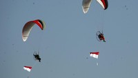 Pilot paramotor mengibarkan bendera Merah Putih di ketinggian dalam pemecahan rekor Museum Rekor Indonesia (MURI) di Lanud Atang Sendjaja (ATS), Kabupaten Bogor, Jawa Barat, Senin (17/8/2020). Cabang olahraga dirgantara Paramotor FASI berhasil memecahkan rekor pengibaran bendera Merah Putih pada ketinggian terbang 2.020 m (6.627 kaki) di atas permukaan tanah, hal tersebut dalam rangka perayaan HUT ke-75 Republik Indonesia. ANTARA FOTO/Yulius Satria Wijaya.