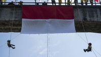 Sejumlah anak membentangkan Bendera Merah Putih di Jembatan Babarsari, Sleman, DI Yogyakarta, Senin (17/8/2020). Pembentangan bendera menggunakan teknik rappelling atau menuruni bidang vertikal menggunakan tali yang diikuti pemanjat anak dari Jogjakarta Climbing Club tersebut untuk memperingati HUT ke-75 Republik Indonesia. ANTARA FOTO/Hendra Nurdiyansyah.