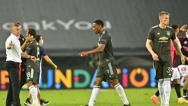 From left, Manchester United's manager Ole Gunnar Solskjaer, Anthony Martial and Scott McTominay leave the field at the end of an Europa League semifinal match between Sevilla and Manchester United, in Cologne, Germany, Sunday, Aug. 16, 2020. Sevilla won 2-1. (AP Photo/Martin Meissner, Pool)