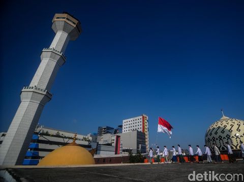 Sejumlah pengurus Dewan Kemakmuran Masjid (DKM) mengarak bendera Merah Putih usai mengikuti upacara peringatan kemerdekaan Republik Indonesia di atap Masjid Raya Bandung, Jawa Barat, Senin (17/8/2020). Pengurus DKM Masjid Raya Bandung berinisiatif untuk menggelar upacara di atap guna turut berpartisipasi dalam memperingati kemerdekaan Republik Indonesia ke-75 dengan menerapkan protokol kesehatan. ANTARA FOTO/Raisan Al Farisi/wsj.