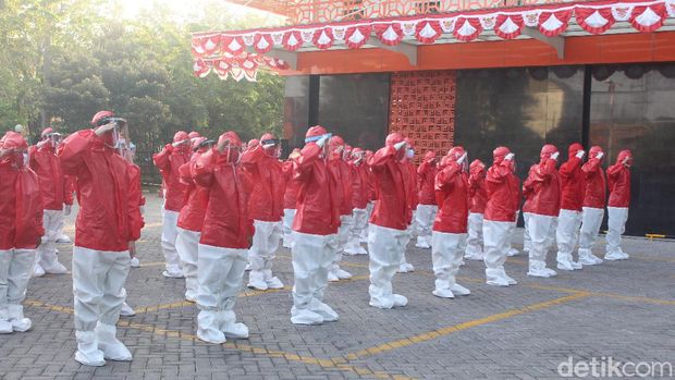 upacara dengan baju hazmat