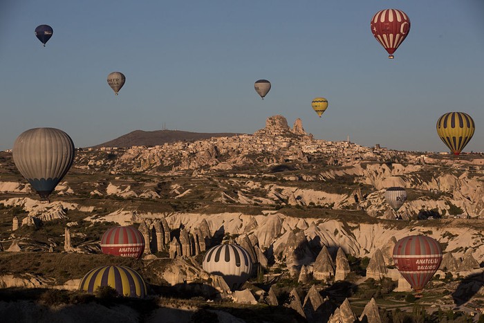 NEVSEHIR, TURKEY - APRIL 18: Tourists look out at the view above a cave hotel on April 18, 2016 in Nevsehir, Turkey. Cappadocia, a historical region in Central Anatolia dating back to 3000 B.C is one of the most famous tourist sites in Turkey. Listed as a World Heritage Site in 1985, and known for its unique volcanic landscape, fairy chimneys, large network of underground dwellings and some of the best hot air ballooning in the world, Cappadocia is preparing for peak tourist season to begin in the first week of May.  Despite Turkey's tourism downturn, due to the recent terrorist attacks,  internal instability and tension with Russia, local vendors expect tourist numbers to be stable mainly due to the unique activities on offer and unlike other tourist areas in Turkey such as Antalya, which is popular with Russian tourists, Cappadocia caters to the huge Asian tourist market.  (Photo by Chris McGrath/Getty Images)
