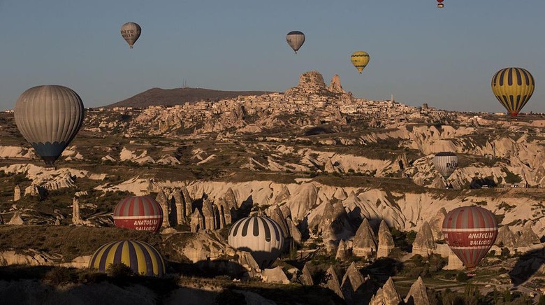 Cappadocia NEVSEHIR, TURKEY - APRIL 18: Tourists look out at the view above a cave hotel on April 18, 2016 in Nevsehir, Turkey. Cappadocia, a historical region in Central Anatolia dating back to 3000 B.C is one of the most famous tourist sites in Turkey. Listed as a World Heritage Site in 1985, and known for its unique volcanic landscape, fairy chimneys, large network of underground dwellings and some of the best hot air ballooning in the world, Cappadocia is preparing for peak tourist season to begin in the first week of May. Despite Turkeys tourism downturn, due to the recent terrorist attacks, internal instability and tension with Russia, local vendors expect tourist numbers to be stable mainly due to the unique activities on offer and unlike other tourist areas in Turkey such as Antalya, which is popular with Russian tourists, Cappadocia caters to the huge Asian tourist market. (Photo by Chris McGrath/Getty Images)