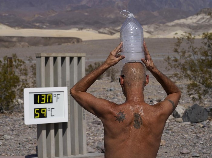 Steve Krofchik cools off with a bottle of ice water on his head Monday, Aug. 17, 2020, in Death Valley National Park, Calif. Death Valley recorded a scorching 130 degrees (54.4 degrees Celsius) Sunday, which if the sensors and other conditions check out, would be the hottest Earth has been in more than 89 years and the third-warmest ever measured. (AP Photo/John Locher)
