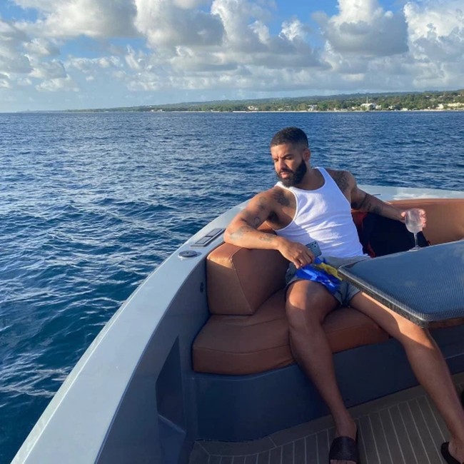 Santai sejenak di pantai Barbados, Drake tampak menyesap minuman beralkohol saat duduk relaks di perahu boat. Foto: Instagram