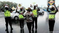 Petugas kepolisian tampak mengenakan masker dan membawa poster saat menggelar sosialisasi pencegahan penyebaran virus Corona.