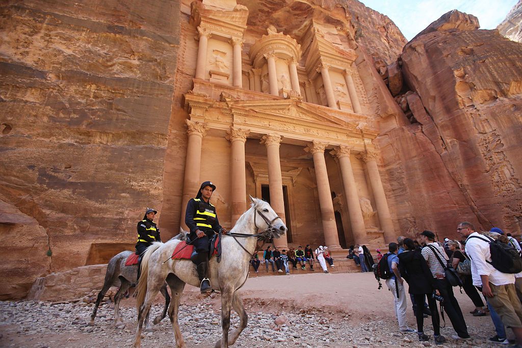 PETRA, JORDAN- APRIL 3: Tourists watch a horse pull a carriage as they visit the legendary Petra, Jordan's most famous tourist attraction on April 3, 2015 in Petra, Jordan. Stakeholders have put together an urgent marketing plan to 'salvage' the Kingdom's tourism industry by promoting national tourist products in new and traditional markets worldwide, according to Tourism Minister Nayef Al Fayez. Visits to Jordan and its famous archeological site of Petra have plummeted because of unrest in the broader Middle East, and discounts on airfare and tours to the country have yet to bring visitor numbers back to levels seen in years past. The number of Arab tourists has not been affected by the regional turmoil, but the number of visitors to archaeological sites has recently dropped and those who visit these sites are mostly non-Arabs. (Photo by Jordan Pix/ Getty Iimages)