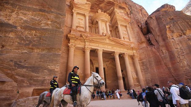 PETRA, JORDAN- APRIL 3: Tourists watch a horse pull a carriage as they visit the legendary Petra, Jordan's most famous tourist attraction on April 3, 2015 in Petra, Jordan. Stakeholders have put together an urgent marketing plan to 'salvage' the Kingdom's tourism industry by promoting national tourist products in new and traditional markets worldwide, according to Tourism Minister Nayef Al Fayez. Visits to Jordan and its famous archeological site of Petra have plummeted because of unrest in the broader Middle East, and discounts on airfare and tours to the country have yet to bring visitor numbers back to levels seen in years past. The number of Arab tourists has not been affected by the regional turmoil, but the number of visitors to archaeological sites has recently dropped and those who visit these sites are mostly non-Arabs. (Photo by Jordan Pix/ Getty Iimages)