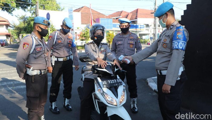 Anggota Polresta Kediri yang tidak mengenakan masker saat berdinas akan diganjar hukuman. Mulai dari membersihkan fasilitas umum, mengenakan helm merah hingga mengatur lalu lintas.