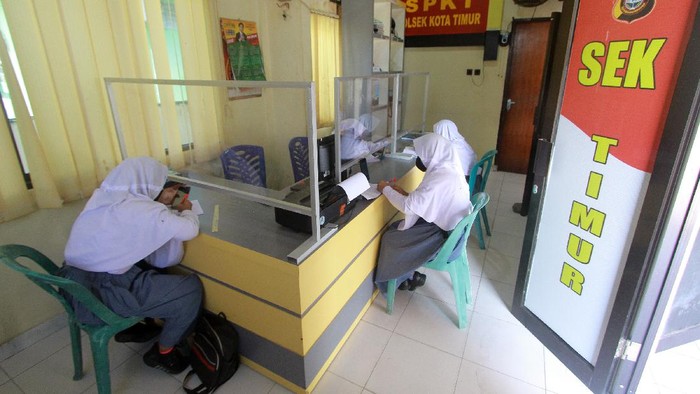 Seorang Bhabinkamtibmas mengawasi sejumlah siswa yang belajar di Polsek Kota Timur, Kota Gorontalo, Gorontalo, Selasa (18/8/2020). Polsek tersebut menyediakan jaringan internet gratis dan ruangan belajar bagi siswa yang tidak memiliki gawai cerdas maupun paket data internet untuk belajar daring sejak bulan Juli 2020 lalu. ANTARA FOTO/Adiwinata Solihin/foc.