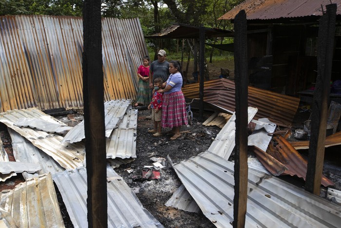 40 Keluarga Adat di Guatemala Kehilangan Rumah Akibat Serangan Kelompok Bersenjata Floricelda Cucul, front right, stands with her husband Celestino Bol and children in the rubble of their shack home burned down by unidentified, armed men, as she returns days after the attack to see what remains where they live on a coffee plantation in Cubilguitz, Guatemala, Tuesday, Aug. 18, 2020. Indigenous families have been living here for years as the result of a long-running labor dispute, and on Monday, President Alejandro Giammattei said the attackers had been identified. (AP Photo/Moises Castillo)