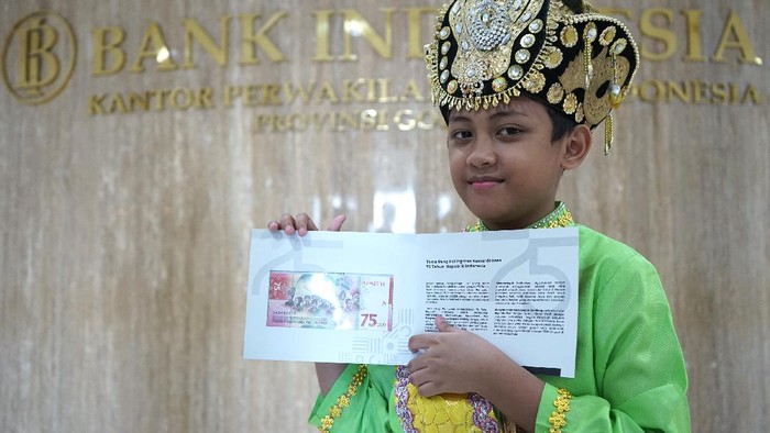 ANAK KENAKAN PAKAIAN ADAT MAKUTA DALAM PECAHAN UANG 75.000 Aditya Perpatih menunjukkan Uang Peringatan Kemerdekaan (UPK) 75 tahun kemerdekaan Indonesia senilai Rp75 ribu di Kantor Perwakilan (KPw) Bank Indonesia (BI) Provinsi Gorontalo di Kota Gorontalo, Gorontalo, Rabu (19/8/2020). Aditya merupakan salah seorang anak yang mengenakan pakaian adat Gorontalo yaitu Makuta dan berada di posisi ketiga kanan dalam uang baru tersebut. ANTARA FOTO/Adiwinata Solihin/aww.
