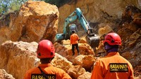 Petugas menggunakan alat berat untuk mencari korban bencana tebing longsor di lokasi galian C penambangan batu di desa Katekan.
