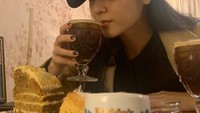 Kesukaannya dengan kopi ia tunjukan lagi di foto berikut ini. Tak hanya menikmati kopi, ia juga menikmati sepotong kue pisang yang manis. Foto: Instagram @vousmevoyez