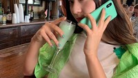 Kalau foto sebelumnya serba merah, kali ini Krystal Jung berpose dengan minuman berwarna hijau tosca dengan outfit, case ponsel, dan kukunya yang serba hijau. Foto: Instagram @vousmevoyez