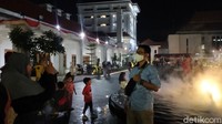 Warga terlihat gembira dan saling berfoto ria dengan menggunakan handphone.
