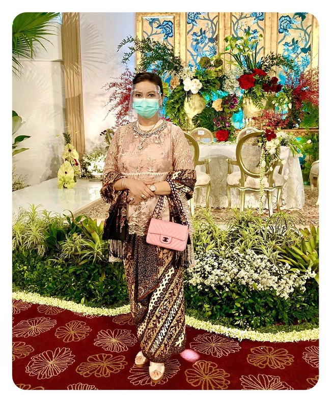 3. Inilah penampilan Bella Saphira saat menghadiri sebuah acara pernikahan. Kebaya pink bergaya baju kurung dengan padanan tas Chanel klasik menjadi andalanya. Tidak ketinggalan masker medis dan face shield. (Foto: Instagram)