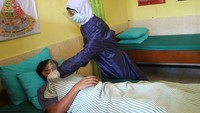 Petugas UKS yang mengenakan APD memperagakan cara merawat pelajar yang sakit saat Simulasi Pembelajaran Sekolah Dengan Protokol Kesehatan. Simulasi tersebut diadakan untuk melatih para siswa dan guru dalam penerapan protokol kesehatan di lingkungan sekolah guna mencegah penyebaran COVID-19. ANTARA FOTO/Ari Bowo Sucipto  