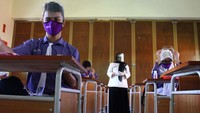 Di Malang, pelajar mengikuti proses belajar mengajar dengan mengenakan masker dan pelindung wajah (face shield) saat Simulasi Pembelajaran Sekolah Dengan Protokol Kesehatan di SMPN 8 Malang, Jawa Timur, Rabu (19/8/2020). ANTARA FOTO/Ari Bowo Sucipto  