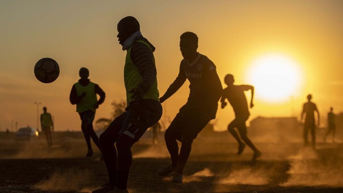Bermain Bola di Lapangan Berdebu Soweto People plays soccer in a dusty field in Soweto, South Africa, Wednesday, Aug. 19, 2020. South African president Cyril Ramaphosa announced that the entire country move to lockdown alert level 2 from Tuesday. (AP Photo/Themba Hadebe)