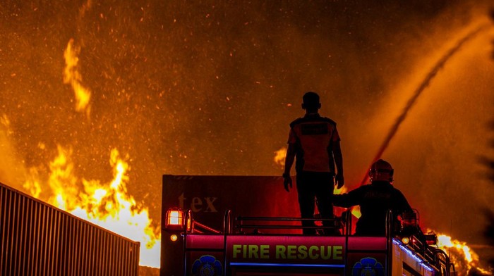 Seorang personel pemadam kebakaran berusaha masuk ke dalam area sebuah pabrik pengolahan kertas yang terbakar di Kawasan Industri Executive, Batam, Kepulauan Riau, Rabu (19/8/2020) malam. Kebakaran tersebut diduga berasal dari konsleting listrik dari salah satu ruang produksi pabrik pengolahan kertas. ANTARA FOTO/M N Kanwa/nz