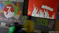 Di salah satu bagian dinding mural tersebut tampak gambar sejumlah petugas dengan mengenakan alat pelindung diri (APD) memegang bendera Merah Putih.