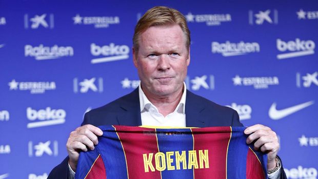 Ronald Koeman holds up a soccer shirt with his name on it during his official presentation as coach for FC Barcelona in Barcelona, Spain, Wednesday, Aug. 19, 2020. Barcelona officially announced earlier on Wednesday a deal with Koeman to become their coach five days after the team's humiliating 8-2 loss to Bayern Munich in the Champions League quarterfinals. Barcelona says the former defender's deal runs through June 2022. Koeman replaces the fired Quique Setien. (AP Photo/Joan Monfort)