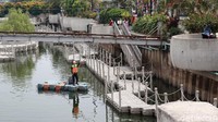 Seorang petugas tampak membersihkan area Kali Besar yang berada di sekitaran Kota Tua, Jakarta.