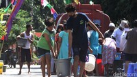 Warga bahu membahu membawa ember berisi air bersih untuk digunakan bagi keperluan sehari-hari.