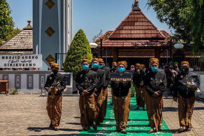 TRADISI KIRAB SURA GIRIKUSUMO Pasukan Patangpuluh Kendi Kasepuhan Girikusumo dengan mengenakan masker mengirab kendi berisi air dari sumur berkah Girikusumo sebagai simbol berkah alam dalam prosesi Tradisi Kirab Sura Girikusumo di Desa Banyumeneng, Mranggen, Demak, Jawa Tengah, Kamis (20/8/2020). Tradisi menyambut tahun baru Islam 1 Muharram 1442 Hijriyah atau satu Sura yang biasanya dihadiri ribuan warga itu, kali ini hanya dihadiri keluarga besar Kasepuhan Girikusumo dengan menerapkan sejumlah protokol kesehatan guna mencegah penyebaran COVID-19. ANTARA FOTO/Aji Styawan/aww.