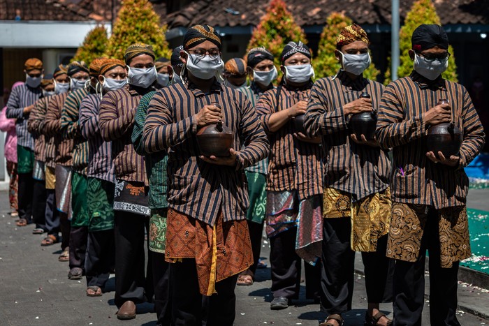 Pasukan Patangpuluh Kendi Kasepuhan Girikusumo dengan mengenakan masker mengirab kendi berisi air dari sumur berkah Girikusumo sebagai simbol berkah alam dalam prosesi Tradisi Kirab Sura Girikusumo di Desa Banyumeneng, Mranggen, Demak, Jawa Tengah, Kamis (20/8/2020). Tradisi menyambut tahun baru Islam 1 Muharram 1442 Hijriyah atau satu Sura yang biasanya dihadiri ribuan warga itu, kali ini hanya dihadiri keluarga besar Kasepuhan Girikusumo dengan menerapkan sejumlah protokol kesehatan guna mencegah penyebaran COVID-19. ANTARA FOTO/Aji Styawan/aww.
