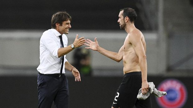 Germany Soccer Europa League Inter Milan's head coach Antonio Conte, left, smiles with his player Diego Godin during the Europa League semifinal soccer match between Inter Milan and Shakhtar Donetsk at Dusseldorf Arena, in Duesseldorf, Germany, Monday, Aug. 17, 2020. (Sascha Steinbach, Pool Photo via AP)