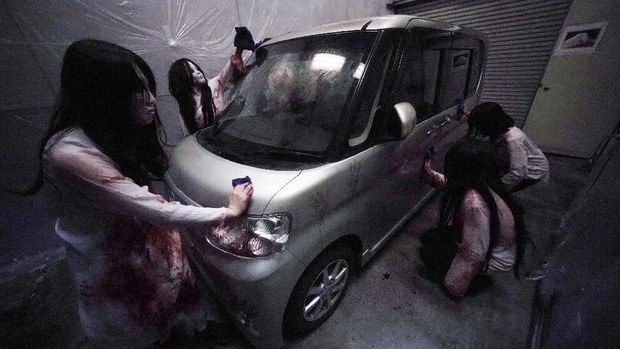Rumah Hantu Drive-in di Jepang (AP/Eugene Hoshiko) Casts as zombies perform by the window of a vehicle during a demonstration of a drive-in haunted house show at a garage Tuesday, Aug. 18, 2020, in Tokyo. Visitors remain in vehicles as taking prevention measures against the COVID-19 pandemic, while ghosts, zombies and other characters spook the visitors. Visitors could experience the entertainment with the safety of being inside their own vehicles. Or, a vehicle provided by the program is also available for rent at the site. (AP Photo/Eugene Hoshiko)