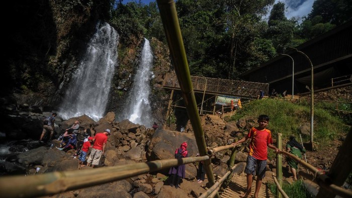 WISATA AIR TERJUN CINULANG Wisatawan menikmati keindahan Air Terjun Cinulang di Cicalengka, Kabupaten Bandung, Jawa Barat, Jumat (21/8/2020). Pengelola air terjun menyatakan, pada libur panjang Tahun Baru Islam 1442 H jumlah wisatawan yang berkunjung ke Air Terjun Cinulang meningkat 50 persen atau sekitar 150 wisatawan per hari dibandingkan hari biasa yang hanya 75 orang. ANTARA FOTO/Raisan Al Farisi/pras.