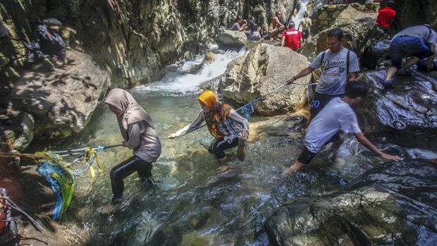 Sejumlah wisatawan menikmati air terjun Leuwi Hejo di Babakan Madang, Kabupaten Bogor, Jawa Barat, Jumat (21/8/2020). Wisata air terjun Leuwi Hejo menjadi salah satu tujuan wisata alam di Bogor pada libur Tahun Baru Islam 1 Muharam 1442 Hijriah dan libur akhir pekan. ANTARA FOTO/Yulius Satria Wijaya/pras.