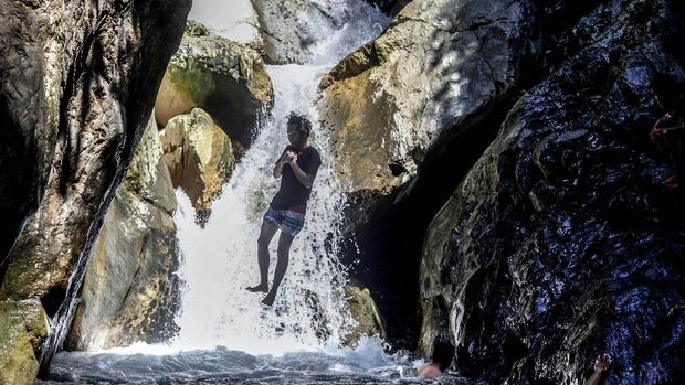 Sejumlah wisatawan menikmati air terjun Leuwi Hejo di Babakan Madang, Kabupaten Bogor, Jawa Barat, Jumat (21/8/2020). Wisata air terjun Leuwi Hejo menjadi salah satu tujuan wisata alam di Bogor pada libur Tahun Baru Islam 1 Muharam 1442 Hijriah dan libur akhir pekan. ANTARA FOTO/Yulius Satria Wijaya/pras.