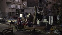 Mahmoud Moussa, dan para pengungsi lainnya beristirahat di antara puing-puing bangunan.