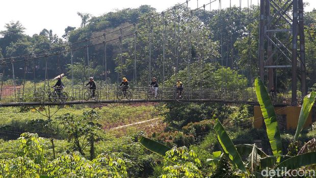 Warga melintas di jembatan gantung di Curug, Depok, Jabar. Jembatan yang membentang di atas Kali Angke tersebut menghubungkan Depok dengan Bogor.
