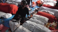 Di lantai tanah beralaskan terpal berwarna biru, terlihat jejeran puluhan jasad yang telah dibungkus (dibalun) menggunakan kain berwarna merah dan putih. Selain menandakan strata sosial almarhum semasa hidup, jasad yang dibungkus berwarna merah diketahui memiliki waktu lebih lama berada di rumah sebelum dimakamkan.  