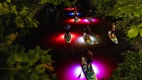 Pemandangan pendayung di atas papan selancar ber-LED di malam hari menjadi tontonan menarik bagi warga sekitarnya.